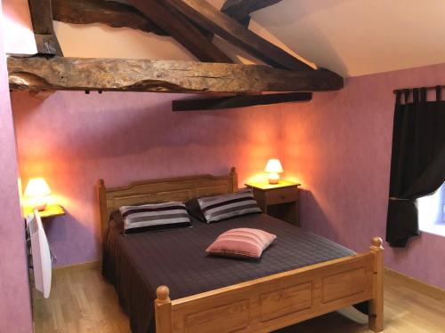une chambre avec un lit avec deux oreillers dessus dans l'établissement Les gites de la Planchette, à Saint-Gervais-les-Trois-Clochers