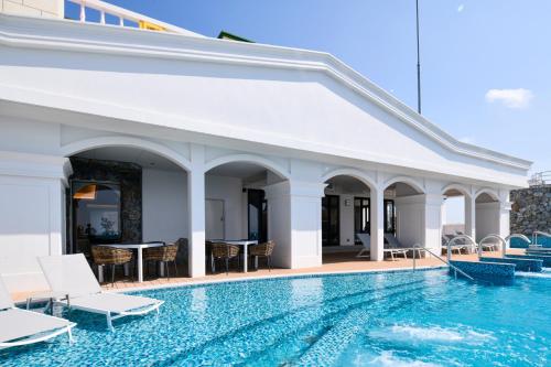 a pool at a hotel with chairs and tables at Lequ Okinawa Chatan Spa ＆ Resort in Chatan