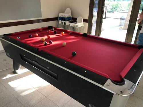 a red pool table with balls on top of it at Camping Castell D'aro in Platja d'Aro