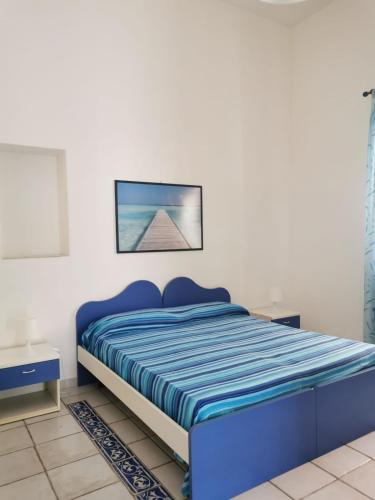 a bedroom with a blue bed and a picture on the wall at ANFORA Blu in Canneto