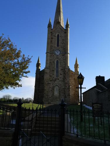a church with a tower with a clock on it at O'Donnell's Of Donegal in Donegal