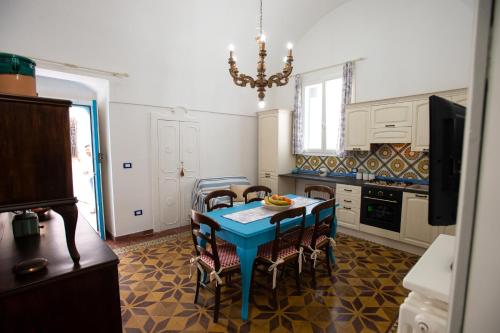 a kitchen with a blue table and chairs in it at La Casa nel Vico in Marittima