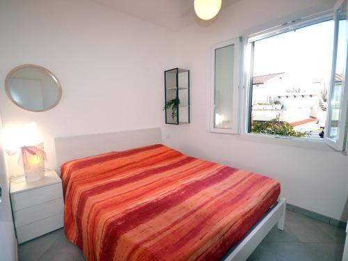 a white bedroom with a bed and a window at SIT Holiday Homes in Lido delle Nazioni