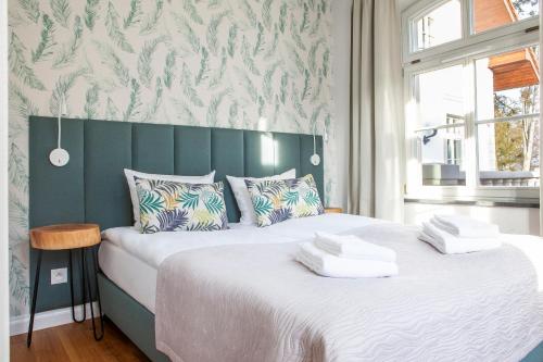 a bedroom with two beds and a green headboard at Leśny Dwór in Sulęczyno
