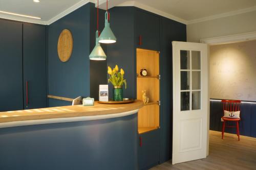 a kitchen with blue walls and a counter top at Hotel am Südwäldchen in Westerland