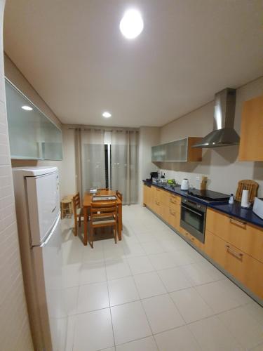 a kitchen with a table and a dining room at Apartamento T3-S.PedroII in Ponta Delgada