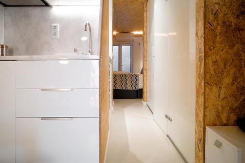 a kitchen with white cabinets and a hallway at Friendly Border City Design Apartments in Lisbon