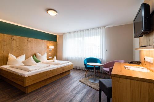 レーゲンスブルクにあるホテル ＆ ガストホフ リチャード ヘルドのベッドとデスクが備わるホテルルームです。