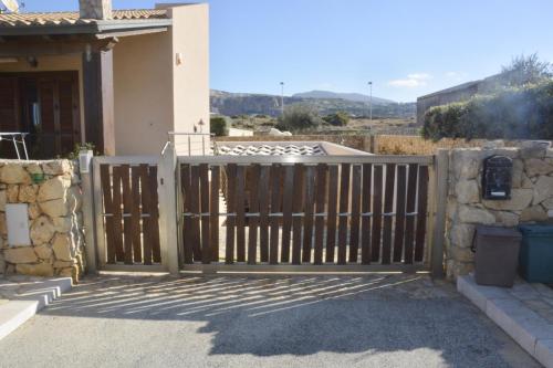 un cancello in legno di fronte a una casa di Cornino Bay a Custonaci