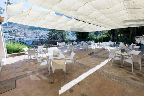 a restaurant with white tables and chairs under a tent at Villa Turística de Cazorla in Cazorla