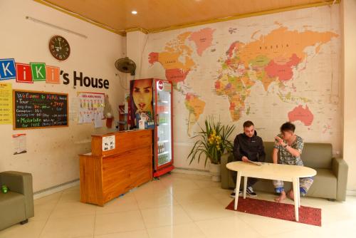 twee personen aan een tafel in een kamer met een kaart bij Kiki's House and motorbike for rent in Ha Giang