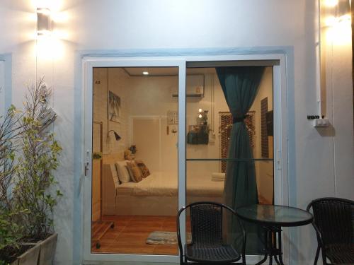 una puerta de cristal que da a un dormitorio con cama en บ้านพักหมอบิวรีสอร์ท en Chiang Khan