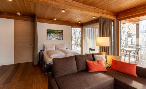 a living room with a couch and a bed at Kronplatz LOFT Bruneck in Brunico