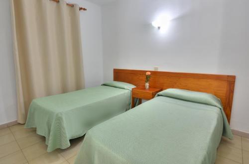 2 camas en una habitación de hospital con sábanas verdes en Apartamentos Luz Y Mar, en Puerto del Carmen