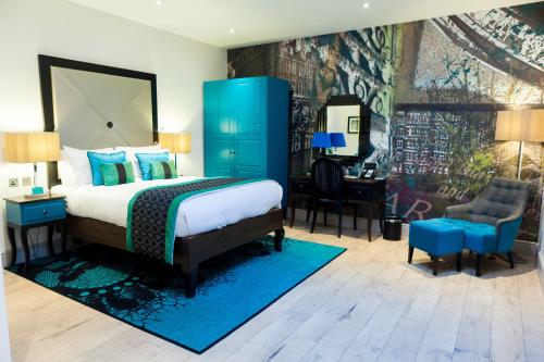 een slaapkamer met een groot bed en een blauwe kast bij Hotel Indigo London - Kensington, an IHG Hotel in Londen