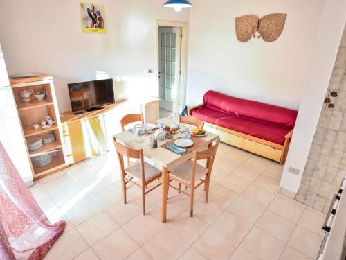een woonkamer met een tafel en een rode bank bij Apartment Green Marine- Palme- Ismare-7 by Interhome in Silvi Marina