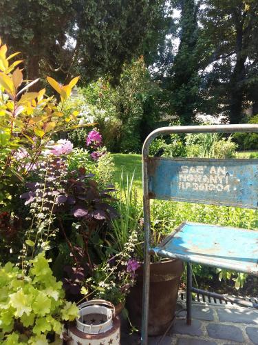 un banco azul sentado en un jardín con flores en Maison Mathilde en Valenciennes