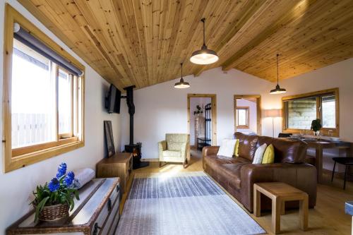 a living room with a couch and a table at Laurel Lodge - 2 Bedroom Log Cabin - St Florence in Saint Florence