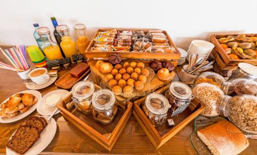 a table with many different types of bread and pastries at Aparthotel Trainera in Esterri d'Àneu