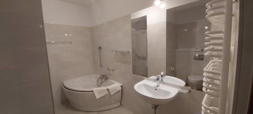 a white bathroom with a toilet and a sink at Yuca in Łódź