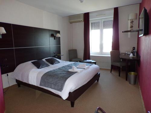 a bedroom with a large bed with two towels on it at Logis Hotel Schaeffer- Restaurant Le Saint Georges in Serrières