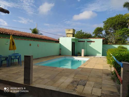 a swimming pool in front of a house at Pousada Lagoa de Araruama in Araruama