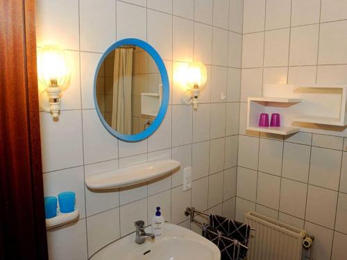 y baño con lavabo y espejo. en La Casa Ferienwohnung Strandlaeufer, en Steinberg