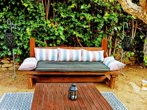 a wooden bench with two pillows on a patio at Hostal Boutique Los Geranios del Pinar in Torremolinos