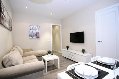 a living room with a couch and a tv at MUNNE - Spacious apartments FC Barcelona in Barcelona