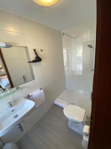 Baño blanco con lavabo y aseo en Bold´S Hotel-Restaurant "Zum Grünen Kranz" en Rodalben