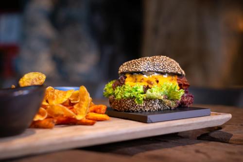 a sandwich and french fries on a cutting board at mama thresl in Leogang