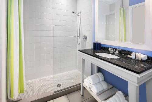 a bathroom with a sink and a shower at Hotel Indigo Houston at the Galleria, an IHG Hotel in Houston