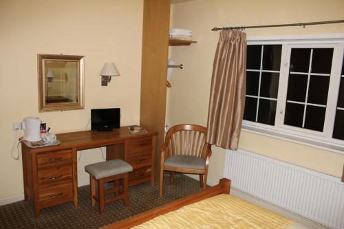 a room with a desk with a computer and a window at The Haymaker Inn in Chard