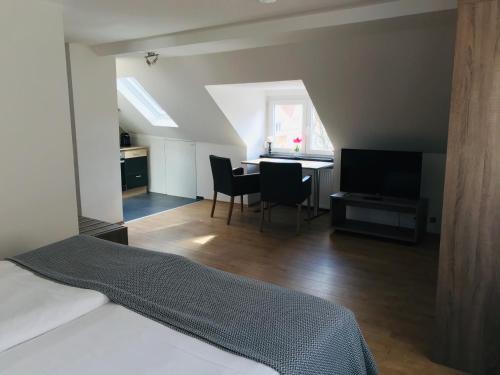 1 dormitorio con 1 cama y comedor con mesa en Hotel Langhans, en Abstatt