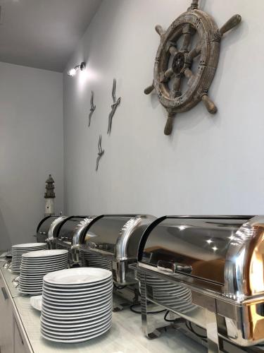 a table with plates and a wheel on a wall at Hotel Morskie Oko in Jurata