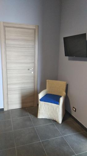 a room with a wicker chair and a door at B&B Vecchia Darsena in Augusta