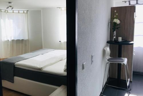 a bedroom with a bed and a chair in it at Hotel Langhans in Abstatt