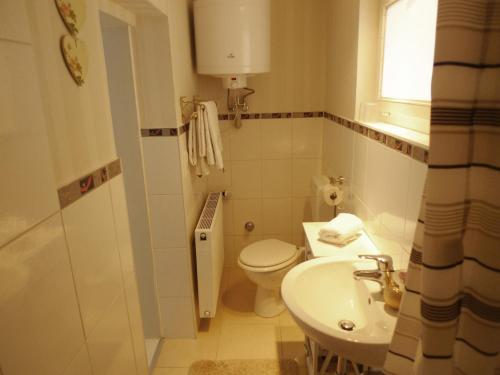 een witte badkamer met een toilet en een wastafel bij gemütliches Gästehaus Berlin Bohnsdorf, nähe Flughafen Schönefeld in Berlijn
