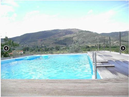 een groot blauw zwembad naast een houten terras bij Belvilla by OYO Tillia in Castiglion Fiorentino