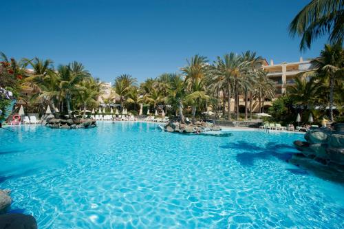 a large swimming pool surrounded by palm trees at Palm Oasis Maspalomas in Maspalomas