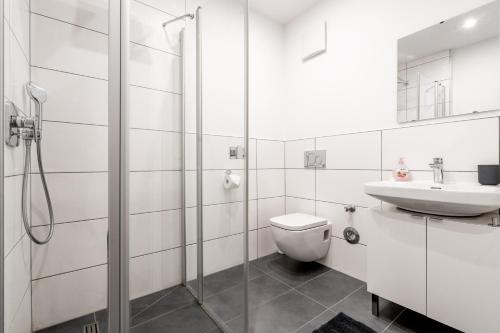 Baño blanco con aseo y lavamanos en Eddy's Rest & Relax - Neuhausen en Múnich