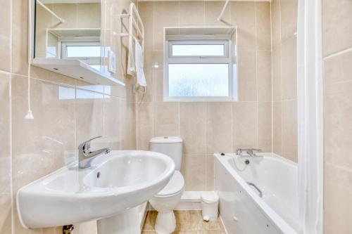 a bathroom with a sink and a toilet and a tub at Del Mar Court in St Martin Guernsey
