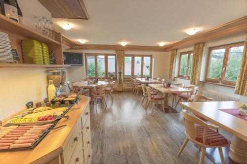 un ristorante con tavoli e sedie in una stanza di Gästehaus Birkenhof a Oberstdorf