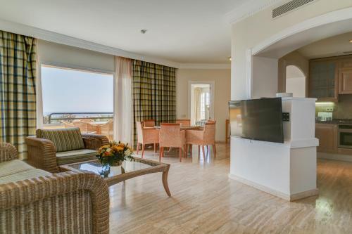 
a living room filled with furniture and a tv at Palm Oasis Maspalomas in Maspalomas
