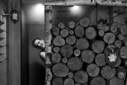 a man is leaning against a wall with a tree at Hotel Bären Titisee in Titisee-Neustadt