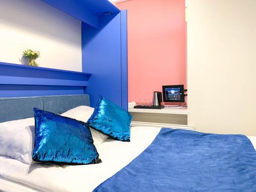 een slaapkamer met blauwe en roze muren en een bed met blauwe kussens bij Smart Welcome by ACADEMIA in Sint-Petersburg