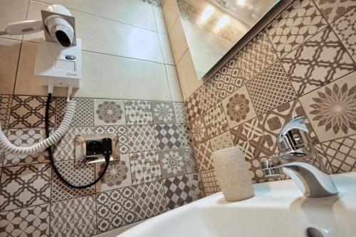 une salle de bain avec un lavabo et un miroir dans l'établissement La corte di Angelica, à Sciacca