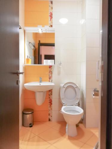 a bathroom with a toilet and a sink at Akra Apartments in Chernomorets