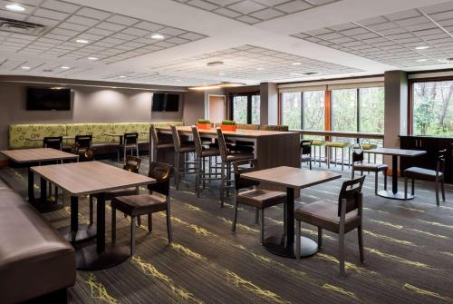 ein Esszimmer mit Tischen und Stühlen und Fenstern in der Unterkunft Wingate by Wyndham Columbia in Columbia