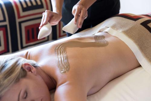 a woman laying on a bed getting her back massage at Hyatt Regency Tamaya South Santa Fe in Santa Ana Pueblo
